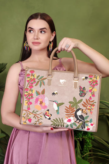 Woman holding a floral and bird-patterned handbag against a green background